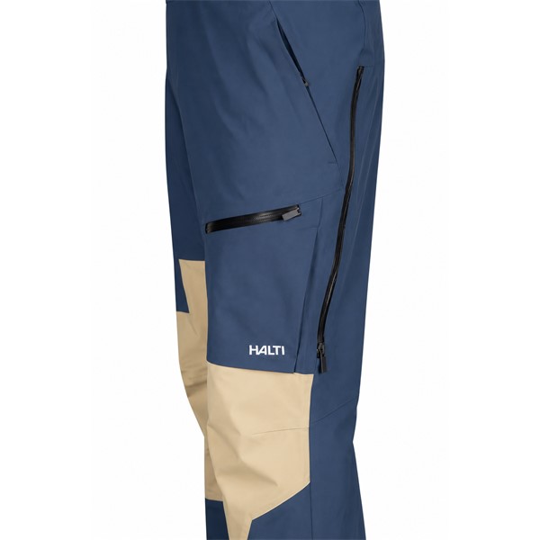 Unisex smučarske hlače HALTI Rizle 3L DX Sargasso Sea Blue v modri barvni kombinaciji G36. Napredna trislojna membrana DrymaxX Nano zagotavlja vodni stolpec 25.000 mm in zračnost 20.000 g/m²/24 h. Hlače imajo visok oprsnik, nastavljive naramnice, dvosmerno sprednjo zadrgo, prezračevanje, prostorne žepe, anatomsko oblikovana kolena, ojačitve Stretch Cordura in notranje snežne gamaše.